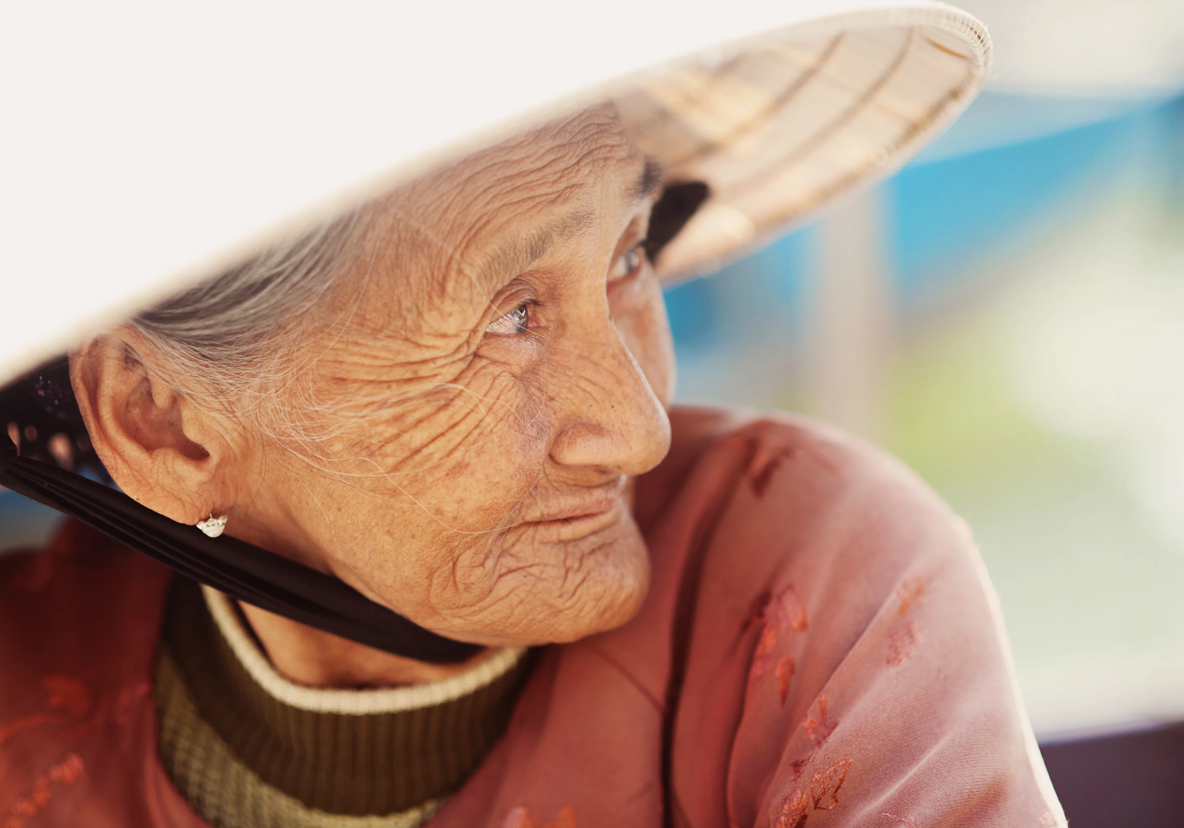 Staršia žena v tradičnom klobúku, symbol dlhovekosti a života v modrých zónach.
